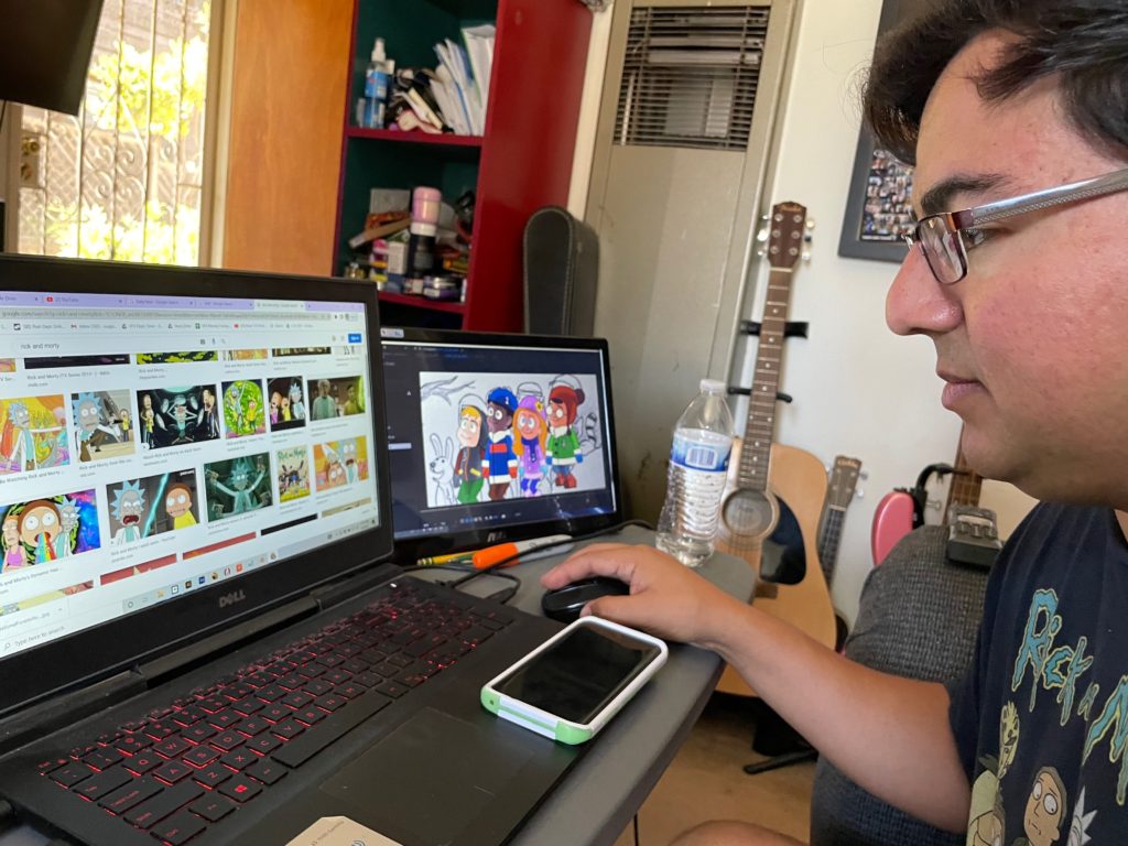 Andres works on his computer with multiple monitors.